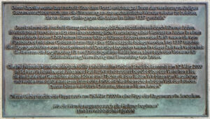 Eine deutsche Tafel mit einem Text über eine Kapelle, historische Anschuldigungen gegen Juden und einen Aufruf zur Versöhnung, der sich auf die Ereignisse im Jahr 1337 und ein Gebet in der Grabeskirche im Jahr 2000 bezieht. (Text mit KI erstellt)