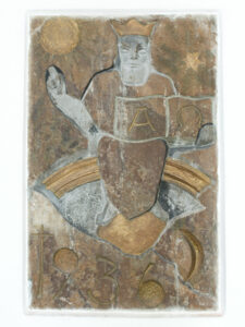 Ein Steinrelief zeigt eine bärtige Figur mit Krone, die auf einem Regenbogen sitzt und ein aufgeschlagenes Buch mit der Aufschrift A und Ω hält. Eine Sonne, ein Stern, ein Kreuz und die Jahreszahl 1936 sind ebenfalls eingemeißelt und in Gold hervorgehoben. (Text mit KI erstellt)