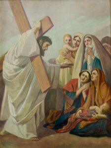 Ein Gemälde zeigt Jesus, der ein Holzkreuz trägt und seine Hand in Richtung einer Gruppe trauernder Frauen und Kinder ausstreckt, die am Straßenrand sitzen und stehen und ihre Trauer und ihr Mitgefühl ausdrücken. (Text mit KI erstellt)