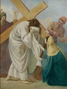 Ein Gemälde von Jesus, der ein Holzkreuz trägt und sein Gesicht mit einem Tuch abwischt, das von einer knienden Frau in einem blau-gelben Gewand gehalten wird, während zwei Männer hinter ihm stehen, einer mit erhobenen Armen, der andere mit einem Seil. (Text mit KI erstellt)