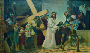 Ein Gemälde zeigt Jesus, der ein großes Holzkreuz trägt, umgeben von römischen Soldaten und Schaulustigen, darunter Frauen und Kinder, auf einer Kopfsteinpflasterstraße. Jesus trägt ein weißes Gewand und eine Dornenkrone. (Text mit KI erstellt)