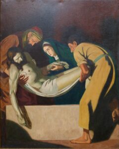 Ein Gemälde zeigt drei Gestalten, die den leblosen, in ein weißes Tuch gehüllten Körper Jesu Christi behutsam in ein Grab hinablassen. Die Szene ist düster, und auf den Gesichtern der Betrachter sind Ausdruck von Trauer und Zärtlichkeit zu sehen. (Text mit KI erstellt)