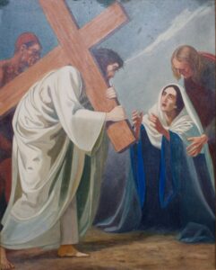 Ein Gemälde zeigt Jesus, der ein großes Holzkreuz trägt, ein weißes Gewand, eine Frau, die kniet und sich ihm entgegenstreckt, und zwei weitere Figuren, die in der Nähe stehen, vor einem gedämpften Hintergrund. (Text mit KI erstellt)