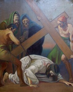 Ein Gemälde zeigt Jesus, der ein großes Holzkreuz trägt und stürzt, während zwei Männer das Kreuz stützen und zwei weitere in der Nähe stehen. Jesus scheint erschöpft zu sein und ist in weiße Gewänder gekleidet. (Text mit KI erstellt)