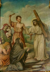Auf einem Gemälde ist Jesus mit einem Kreuz und einer Dornenkrone dargestellt. Ein Wächter erhebt einen Stock in der Nähe, während Frauen, von denen eine ein Kind in der Hand hält, vor einer Naturkulisse im Freien knien und sich Jesus entgegenstrecken. (Text mit KI erstellt)