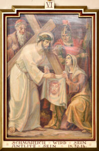 Ein Gemälde zeigt Jesus, der ein Kreuz trägt und eine Dornenkrone trägt, während eine Frau kniet und ein Tuch mit seinem Gesicht darauf hält. Im Hintergrund stehen zwei Soldaten und ein älterer Mann. Unter der Szene erscheint ein Text. (Text mit KI erstellt)