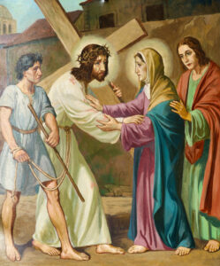 Ein Gemälde zeigt Jesus, der ein hölzernes Kreuz trägt und eine Dornenkrone trägt, während er einer trauernden Frau mit Heiligenschein, wahrscheinlich Maria, begegnet. Zwei weitere Figuren stehen in der Nähe; eine hält ein Seil, die andere stützt Maria sanft. (Text mit KI erstellt)