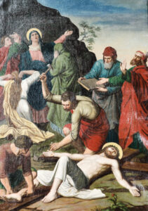 Ein Gemälde zeigt die Beweinung Jesu, mit Trauernden in bunten Gewändern, die sich um seinen leblosen Körper versammelt haben. Mehrere Figuren drücken ihre Trauer aus, einige mit erhobenen Armen, andere knien oder stützen Jesus. (Text mit KI erstellt)
