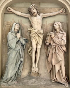 Eine Statue eines Mannes am Kreuz. (Text mit KI erstellt)