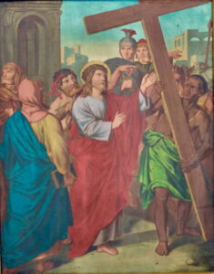 Ein Gemälde zeigt Jesus mit Dornenkrone und rotem Gewand, der ein großes Kreuz trägt, umgeben von Soldaten und Anhängern, wobei ihm ein Mann hilft, das Kreuz durch eine Straße zu tragen. (Text mit KI erstellt)