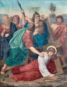 Ein Gemälde zeigt Jesus, der ein Holzkreuz trägt und von römischen Soldaten und Schaulustigen umgeben ist. Ein Soldat hebt eine Waffe, andere gestikulieren oder halten das Kreuz, und Jesus trägt eine Dornenkrone und einen Heiligenschein. (Text mit KI erstellt)