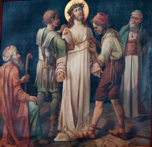 Ein Gemälde zeigt Jesus mit einer Dornenkrone, dem von zwei Männern das Gewand ausgezogen wird, während zwei weitere zusehen. Jesus steht in der Mitte, blickt nach oben und ist von Figuren in historischer Kleidung umgeben. (Text mit KI erstellt)