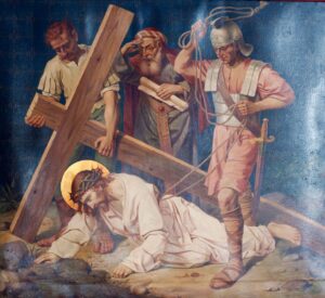 Ein Gemälde zeigt Jesus, wie er unter einem hölzernen Kreuz zusammenbricht und eine Dornenkrone trägt. Zwei römische Soldaten stehen daneben, einer hält eine Peitsche in der Hand. Ein weiterer Mann hilft dabei, das Kreuz hochzuheben. Jesus liegt auf dem Boden und wirkt erschöpft und gequält. (Text mit KI erstellt)
