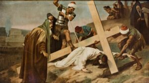 Ein Mann in Weiß, der eine Dornenkrone trägt, ist unter einem großen Holzkreuz zusammengebrochen; um ihn herum stehen Soldaten und Schaulustige auf einem felsigen Pfad. (Text mit KI erstellt)