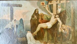 Ein Gemälde zeigt die Kreuzigung Jesu, umgeben von Trauernden. Jesus hängt am Kreuz, daneben liegt eine Dornenkrone, und mehrere Figuren, darunter verschleierte Frauen und Männer in Gewändern, drücken ihre Trauer aus. Eine Figur stützt den Körper Jesu. (Text mit KI erstellt)