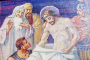 Ein Gemälde, das Jesus mit einer Dornenkrone zeigt, umgeben von vier Männern in antiker Kleidung. Ein Mann ist als römischer Soldat gekleidet, während ein anderer ein weißes Tuch in der Hand hält. Die Szene wirkt düster, die Gesichter spiegeln Besorgnis und Trauer wider. (Text mit KI erstellt)