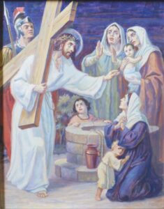 Jesus, der ein hölzernes Kreuz trägt und eine Dornenkrone auf dem Kopf hat, spricht zu einer Gruppe trauernder Frauen und Kinder. Hinter ihm steht ein römischer Soldat. Eine Frau kniet nieder, andere wirken verzweifelt, und ein Kind klammert sich an sie. Die Szene ist bewegend und eindringlich. (Text mit KI erstellt)